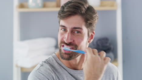 a handsome young man brushing his teeth