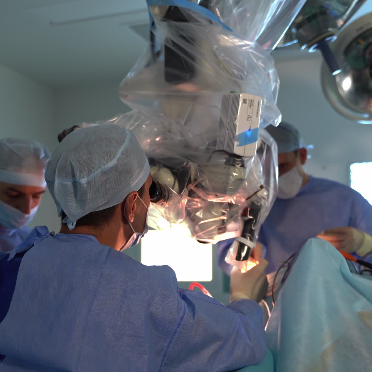 Neurosurgeons working in emergency surgery ward. Team operating doctors in mask in hospital room