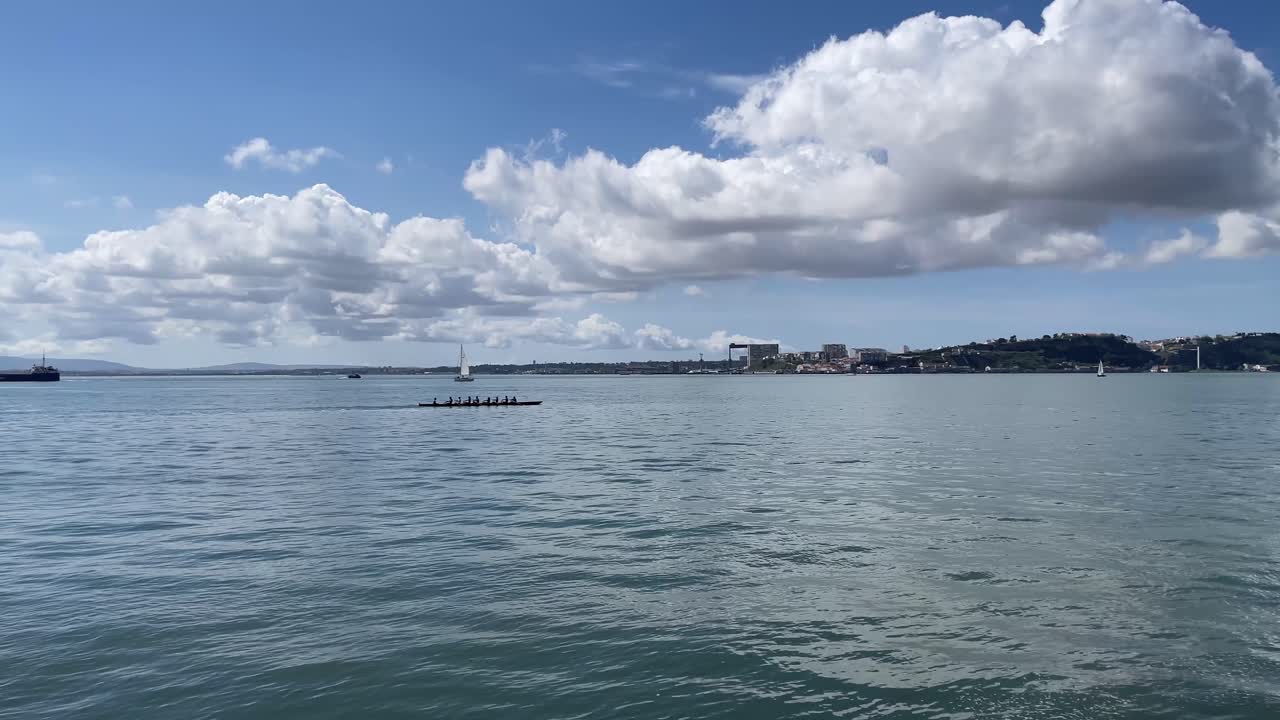 타주스 강, 리스본, 푸른 하늘에 면 구름과 함께 화창한 날에 노를 젓는 팀