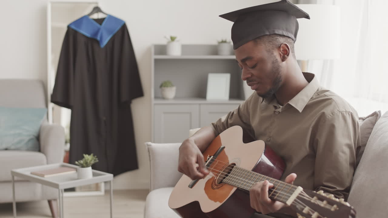 Afro-americano formado tocando violão em casa