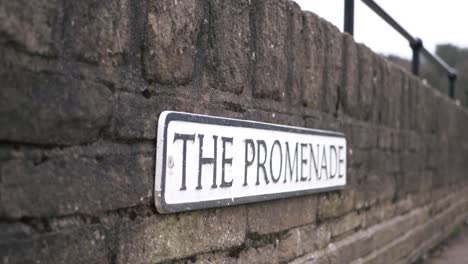 Promenade-street-sign-on-a-wall-wide-panning-shot