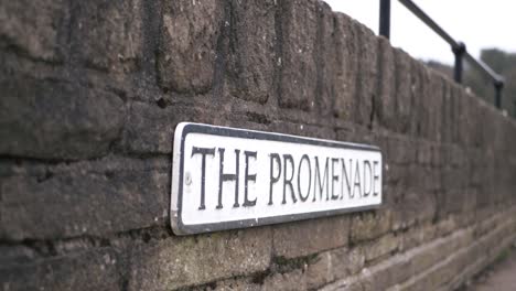 promenade street sign on a wall wide panning shot