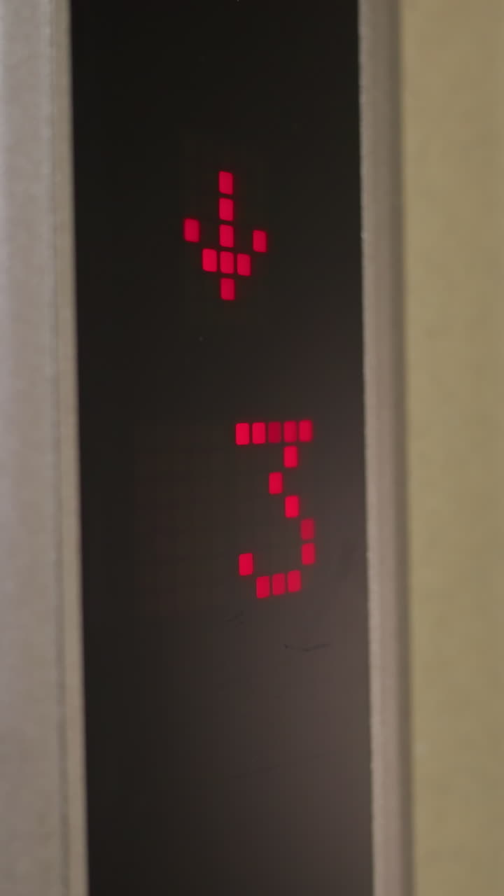 Elevator display showing downward arrow and floor 4, digital red indicator, modern elevator system, business building, corporate setting, elevator in motion, office environment