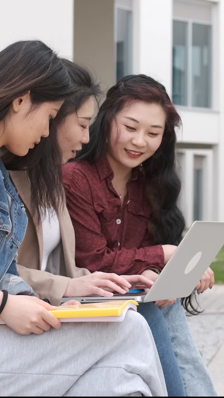 three asian girl students using the laptop at break time sitting on campus