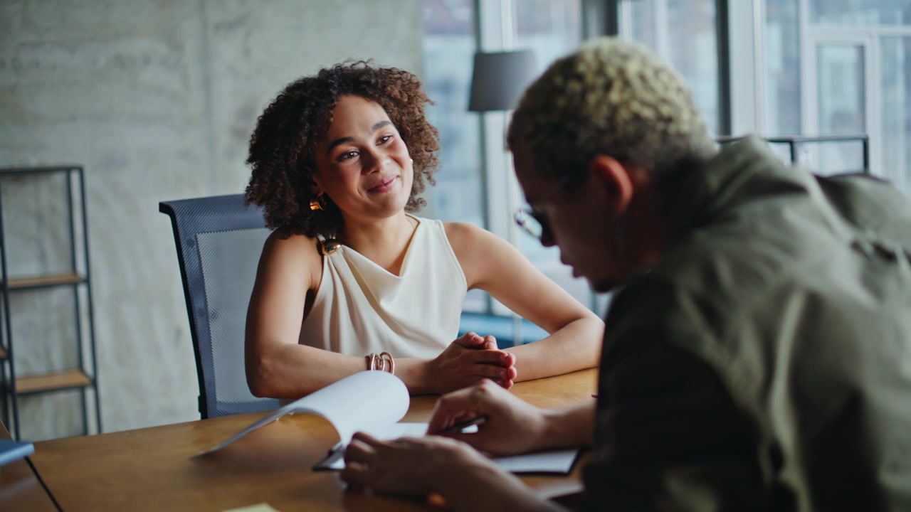 Business woman explaining contract terms in office meeting, client signing deal