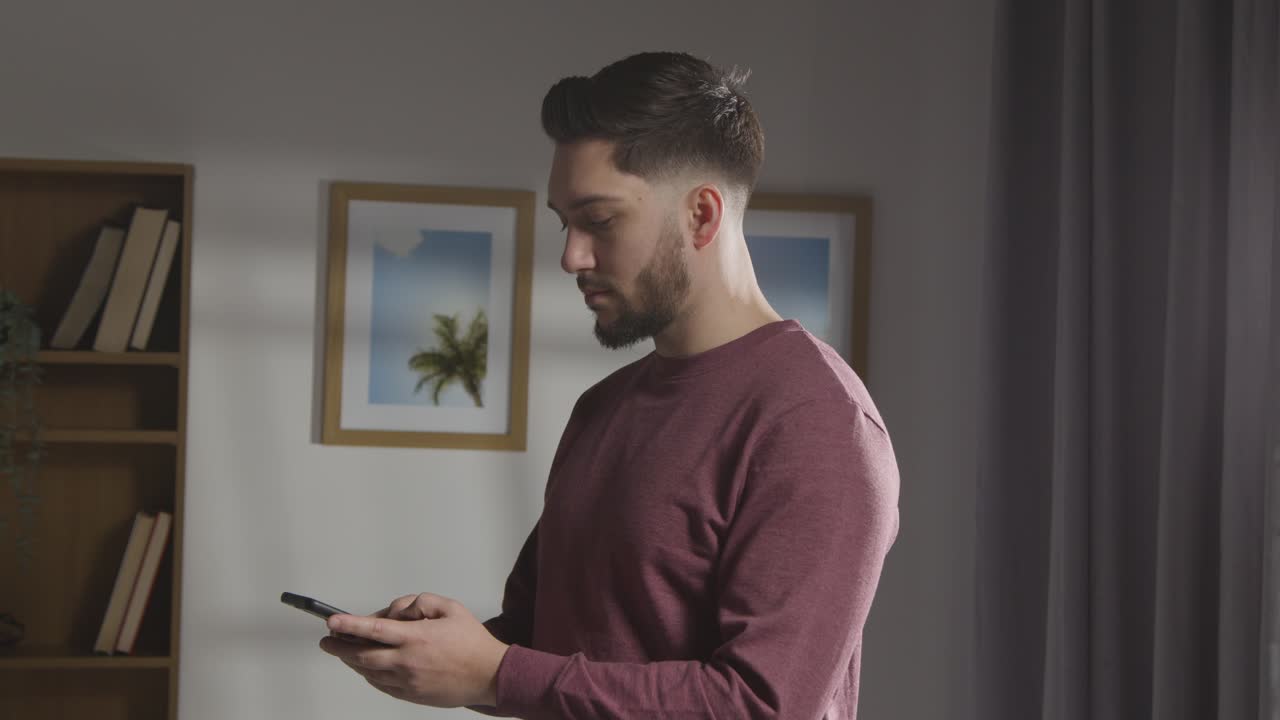 joven complacido en casa recibiendo una llamada telefónica que confirma la oferta de trabajo