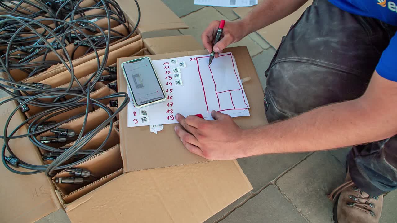 técnico que usa un bolígrafo para dibujar planes para la instalación del cableado del panel solar