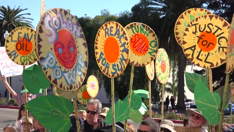 global warming advocates hold signs saying solar power