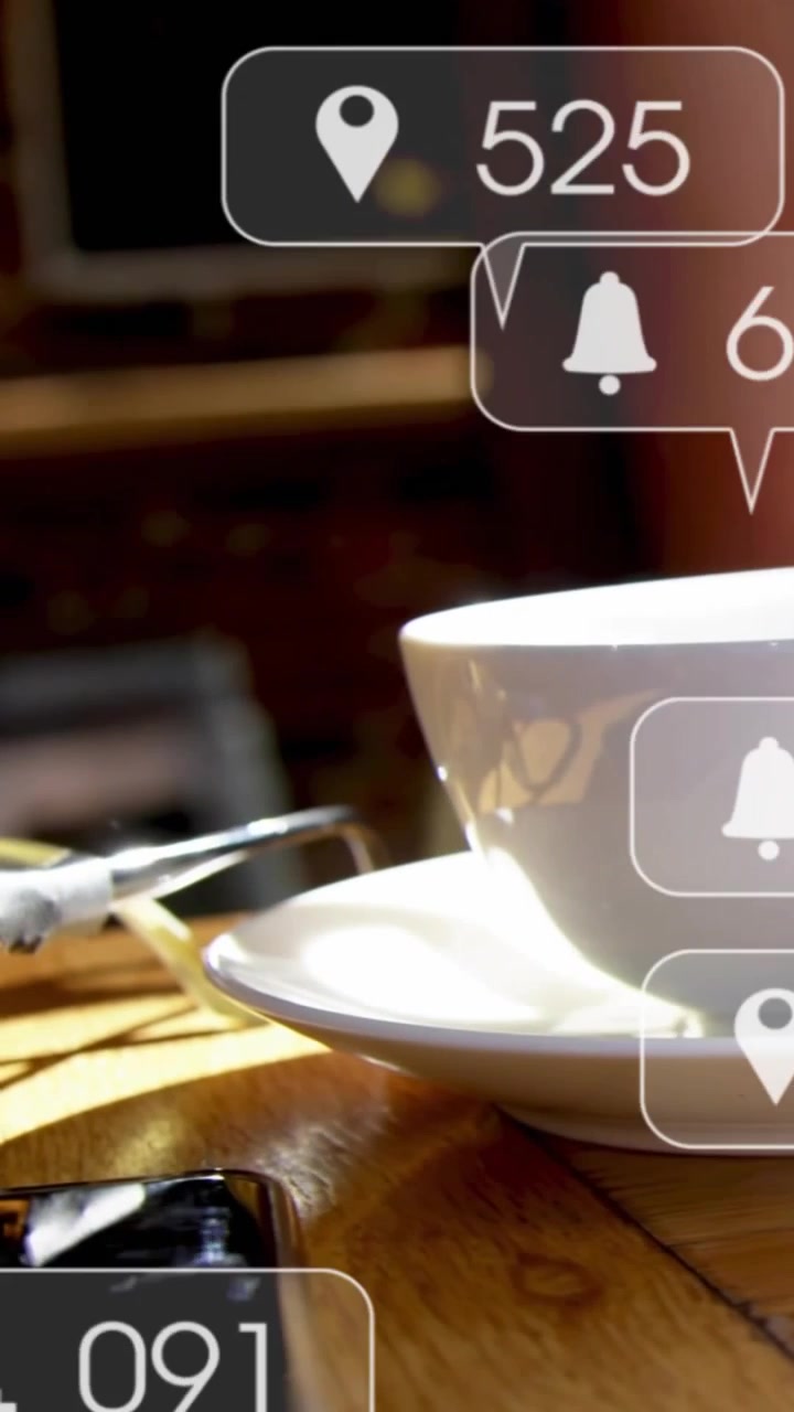Video verticale: Donna che usa il laptop, la telecamera si muove in un caffè e rivela i conteggi di engagement sopra una tazza.