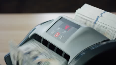 Hands-putting-cash-counter-close-up.-Worker-calculating-hundreds-dollar-bills.