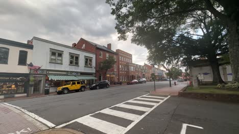 downtown street lined with brick buildings, storefronts, and parked vehicles under cloudy sky in west virginia historic district, capturing local charm and peaceful atmosphere