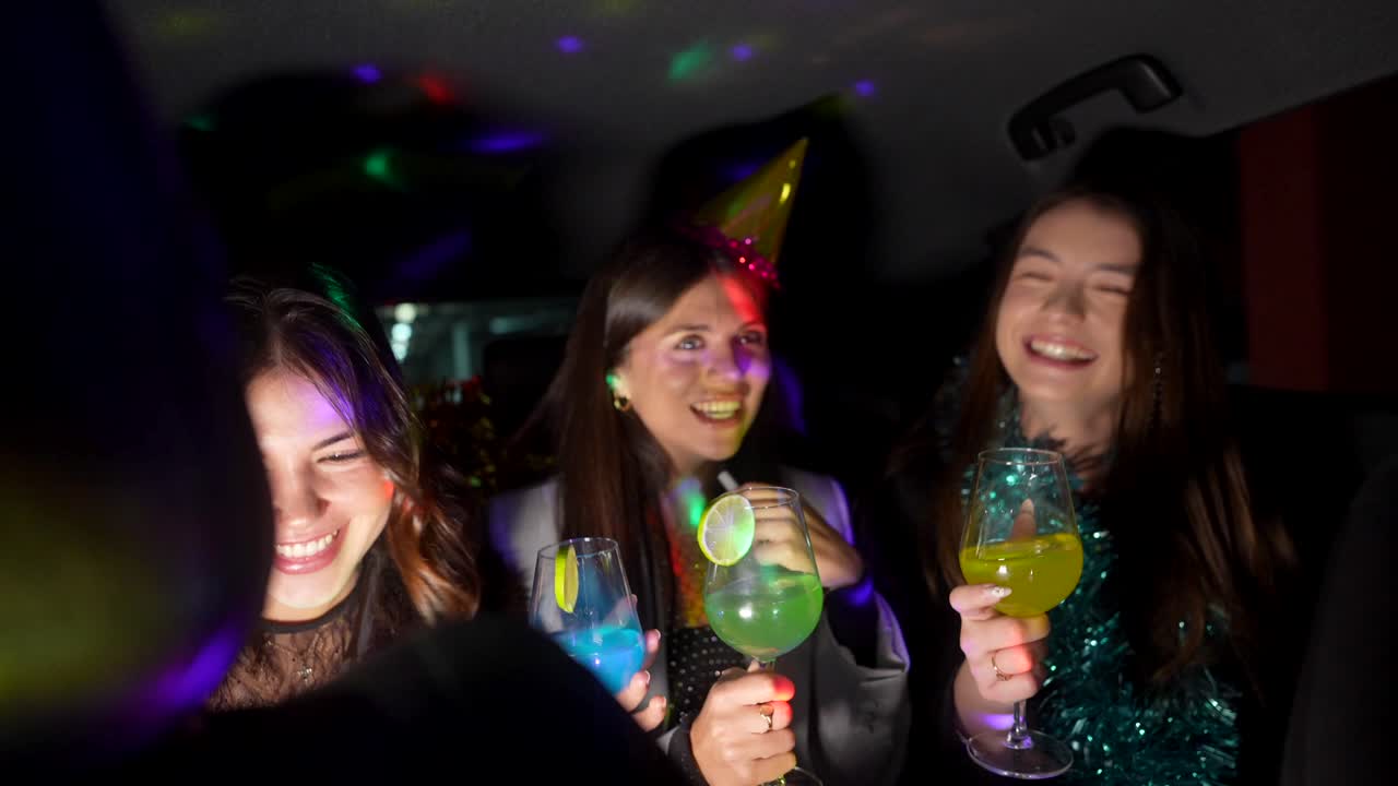 Donne che festeggiano con cocktail in una limousine