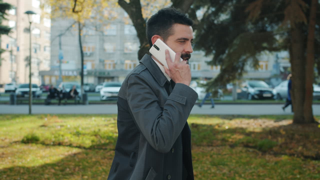 Businessman talking on phone in park