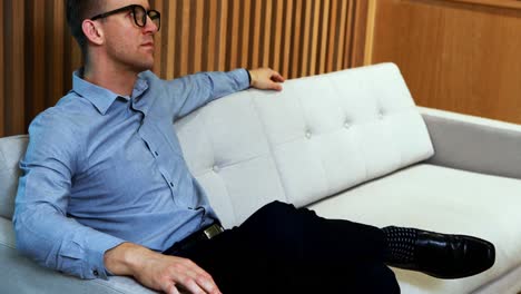 Male-executive-relaxing-on-sofa