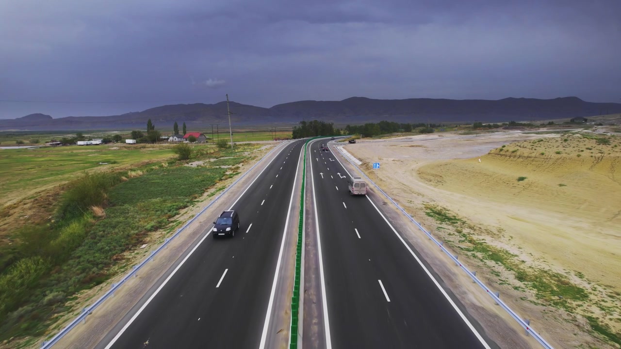 Filmato drone di un'autostrada quasi vuota che porta verso un banco di nuvole scure mentre il volo centrato del drone segue la strada tranquilla registrando la disposizione stradale, la profondità del terreno e il paesaggio del Dagestan
