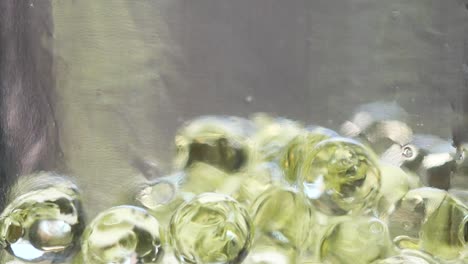 a close-up video of a moist ball falling into a glass bottle.