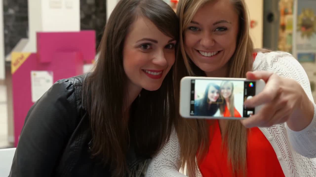 Glade venner drikker kaffe sammen og tager en selfie