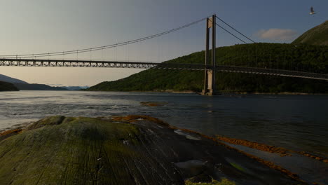 Norwegian-coastal-scenery-of-fjord-with-suspension-bridge-during-sunset