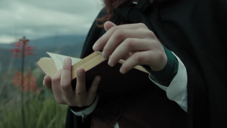 woman's hands read sacred religious bible book in nature in the mountains