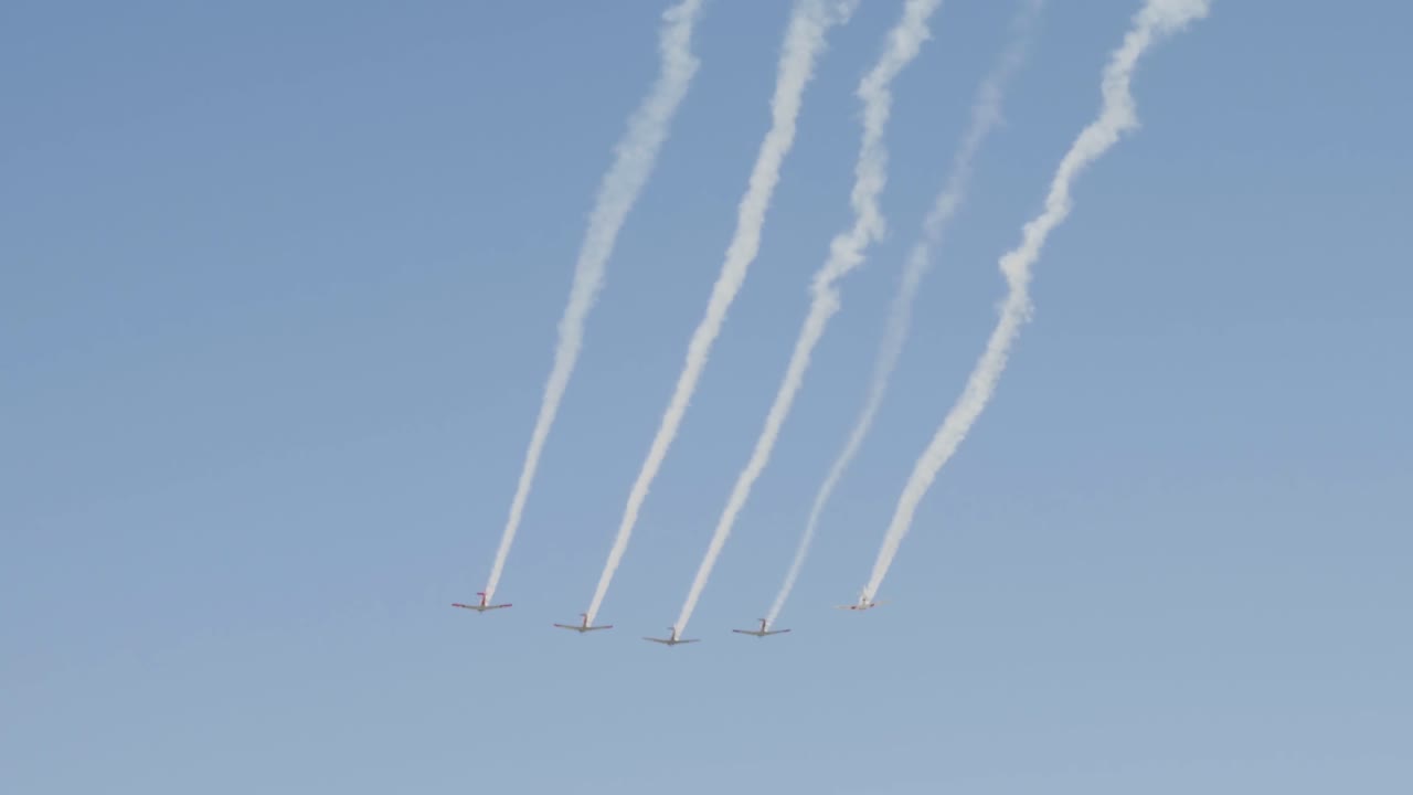 5대의 빈티지 전쟁 비행기가 푸른 하늘에 비행운을 남기고 편대를 이룬다