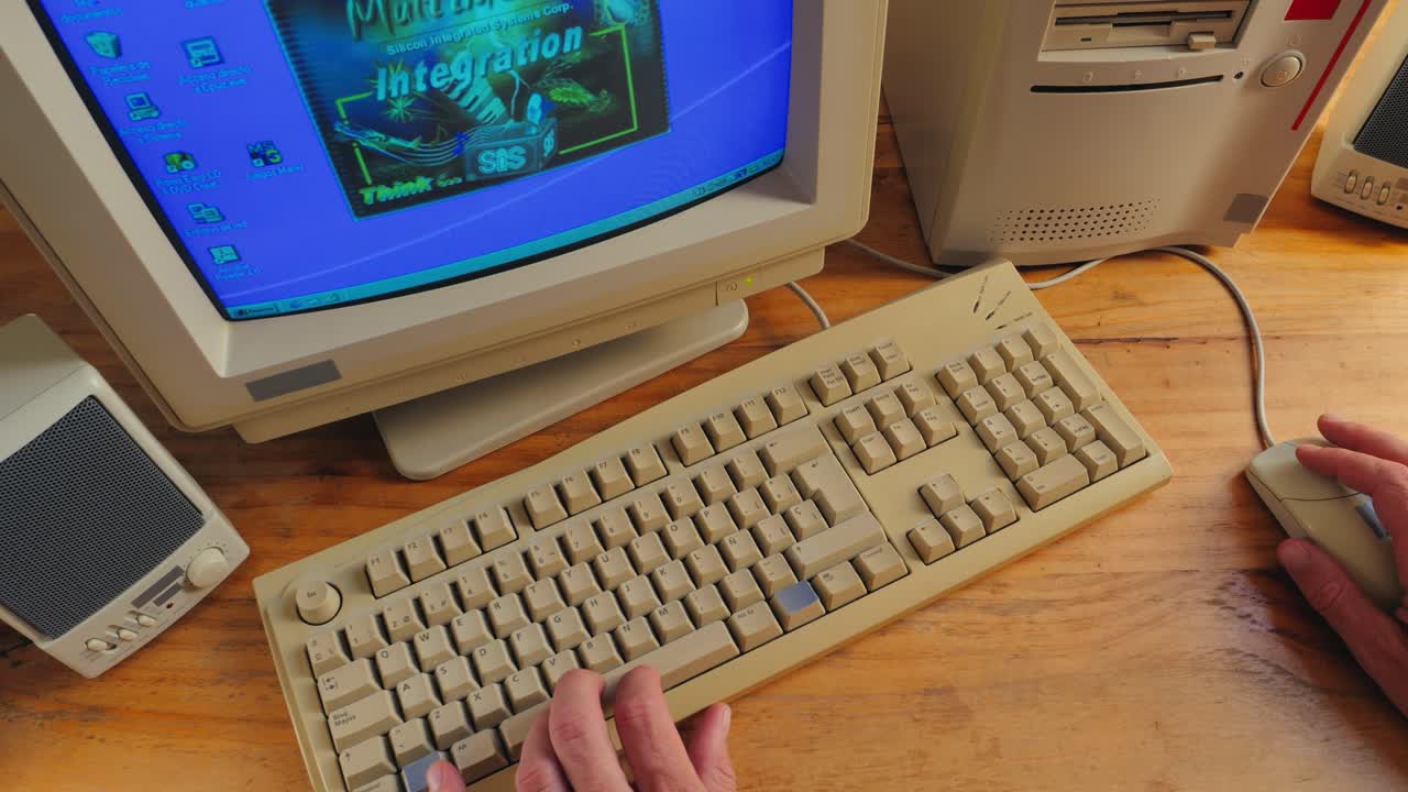 BARCELONA, SPAIN, 10 JUNE 2025. Man working and gaming on retro computer PC, IT engineer with vintage computer at home, using old fashion technology, close up of retro setup.