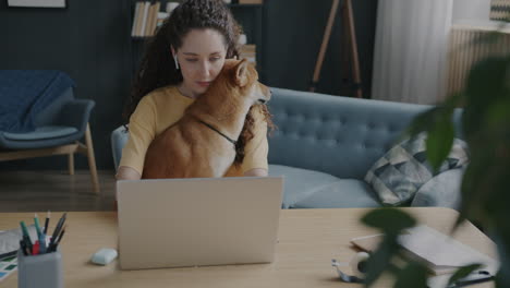 mujer trabajando desde casa con su perro
