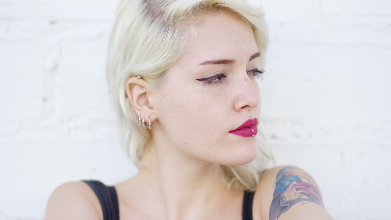 피어싱과 문신을 가진 사려 깊은 스터 여성