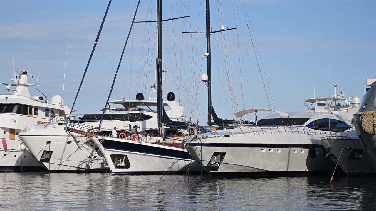 Vista dettagliata di yacht e barche a vela di lusso ormeggiati in un porto.