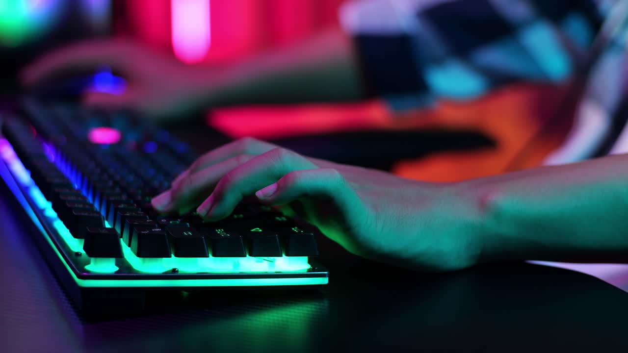 manos de un niño jugador usando el teclado mientras juega un videojuego