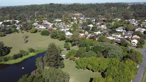 Drohne-Fliegt-In-Richtung-Eines-Kleinen-Sees-Und-Eines-Wohnviertels-In-Australien