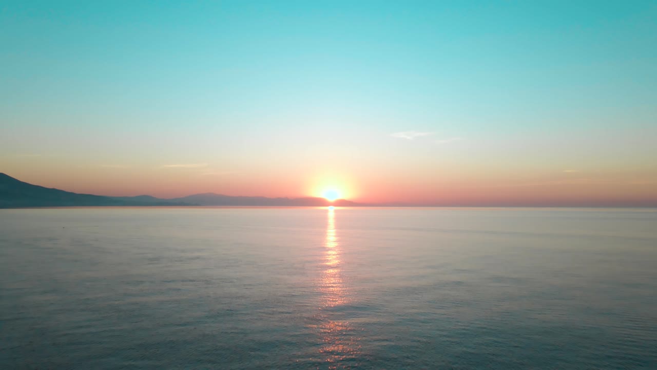 fly over sea revealing  beautiful orange sunset, Costa del Sol, Spain