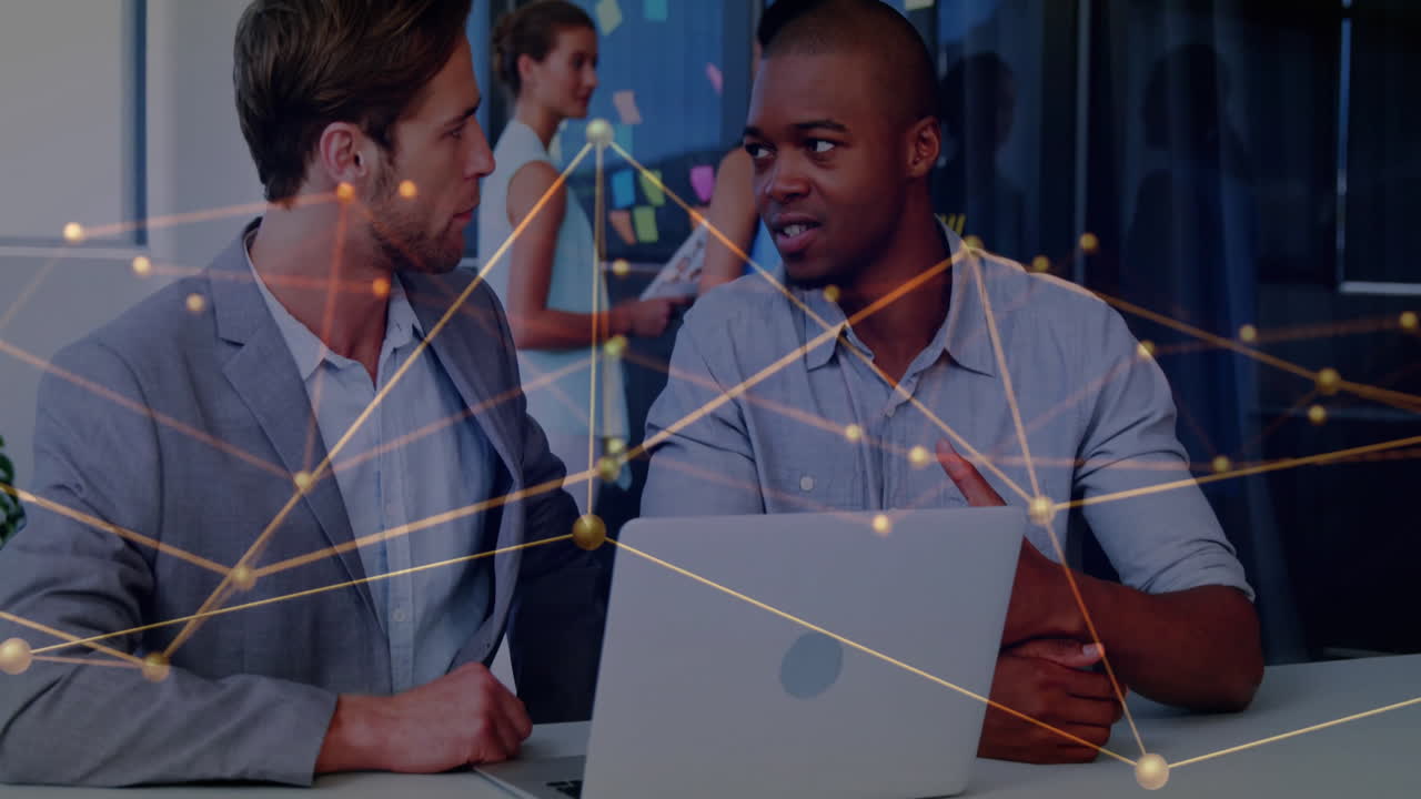 Animation of network of connections over diverse business people using laptop in office