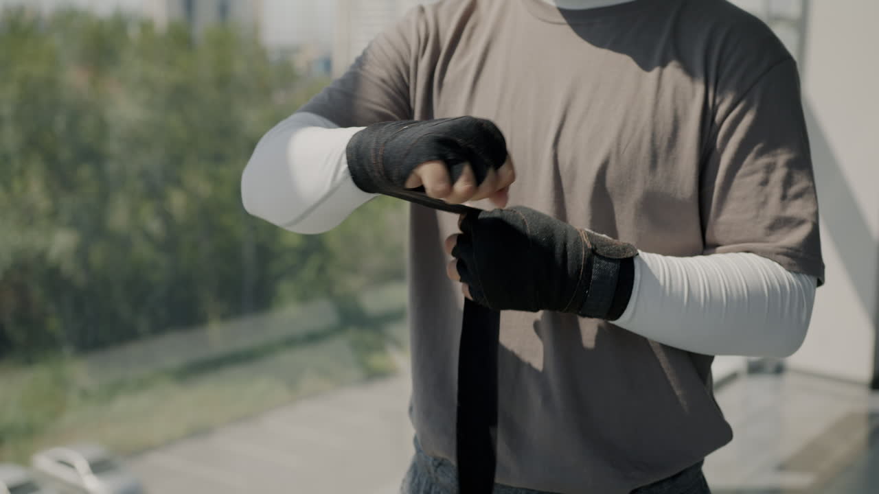Man wrapping boxing hand wraps