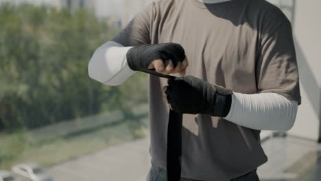 man wrapping boxing hand wraps