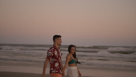 una pareja linda caminando por la playa.