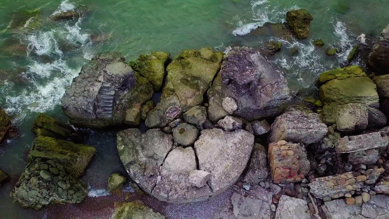 Vue aérienne en plongée de bâtiments de fortification côtiers abandonnés aux Forts Nord de Karosta, sur la plage de la mer Baltique à Liepāja, Lettonie, mer calme, prise de vue par drone grand angle se déplaçant vers la droite