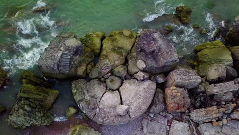 Aerial-birdseye-view-of-abandoned-seaside-fortification-buildings-at-Karosta-Northern-Forts-on-the-beach-of-Baltic-sea-in-Liepaja,-Latvia,-calm-sea,-wide-angle-point-of-view-drone-shot-moving-right