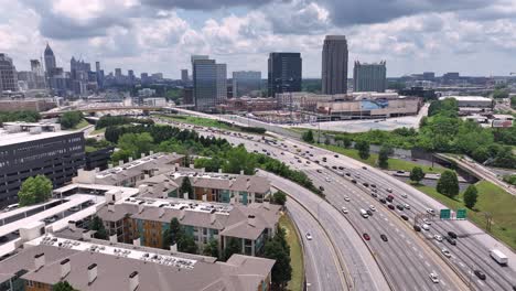 aerial of atlanta expressway moving traffic with modern skyline buildings in background, georgia, usa