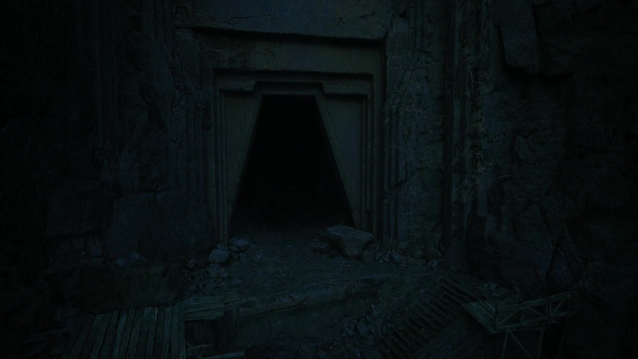 Apertura di una tomba storica incorniciata da rocce aspre e sottili effetti di luce.