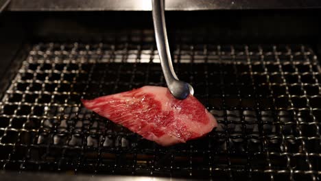 beef slice being grilled on a wire mesh