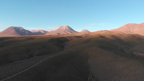 vista panorámica aérea de un camino de tierra con montañas y volcanes