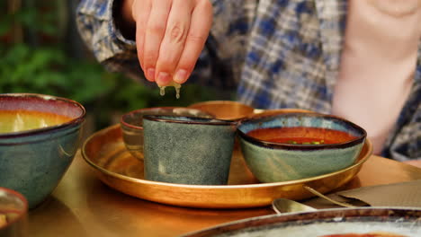 person squeezing lemon over soup