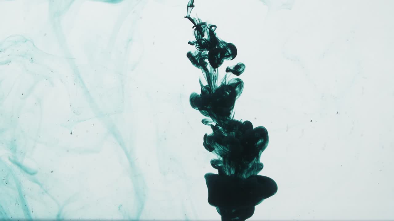 Dark Green Ink Sprayed Into Water On A White Background