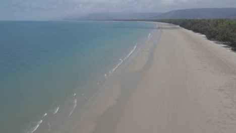 Turistas-Disfrutando-De-La-Arena-De-La-Costa-Y-El-Agua-Azul-Clara-De-La-Playa-De-Cuatro-Millas-En-Port-Douglas,-Fnq,-Australia