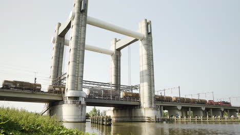 a freight train runs over the third gouwespoorbrug aka hoge gouwe brug in gouda, the netherlands.