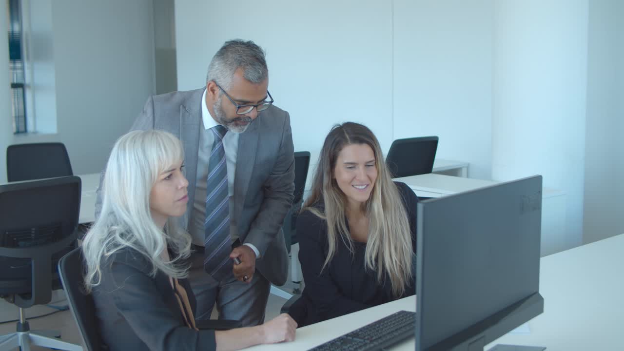 equipo de negocios centrado de tres sentados en el monitor de la computadora