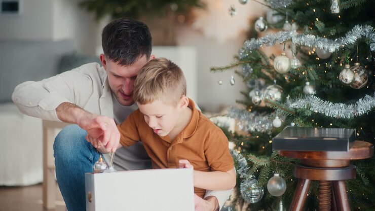 Father And Son Unpacking Christmas Decorations From A Box