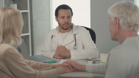 a young black doctor in a medical consultation with a ederly couple 1