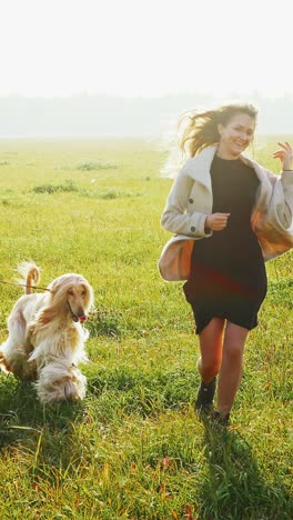 Woman and Dog Running in a Field