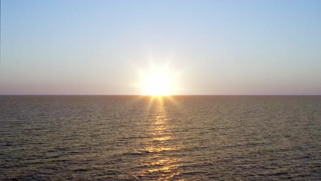 drone 4k altitud media flotar sobre las olas del océano al atardecer
